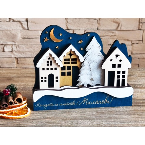 Christmas village with white houses and a snow-covered tree