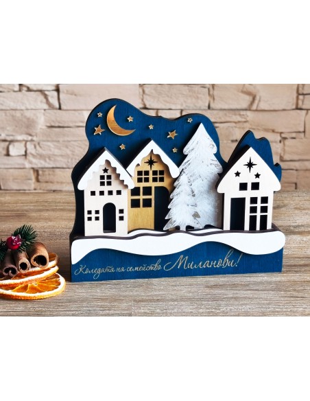 Christmas village with white houses and a snow-covered tree